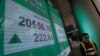 A man walks past an electronic board showing Hong Kong share index outside a local bank in Hong Kong, Jan. 8, 2016. 