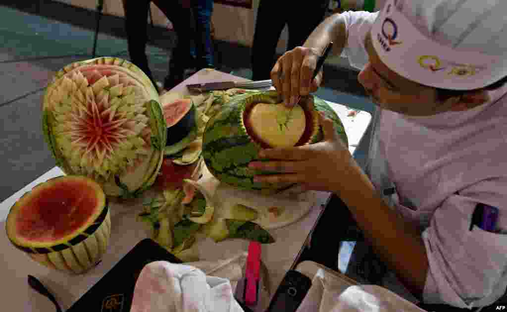 An Indian chef carves a watermelon during a fruit and vegetable carving compitition at 'Culinary Art India 2014' at Pragati Maidan in New Delhi. 250 chefs come together, under one roof to show-off their culinary skills.