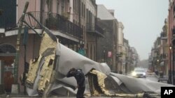 Mtu mmoja akipita eneo la French Quarter ambapo paa la nyumba limeng'olewa na kimbunga Ida huko NMew Orlens Louisiana. Jumapili Agosti 2021.