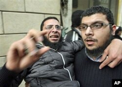 Des manifestants évacuant un blessé de la Place Tahrir, au Caire