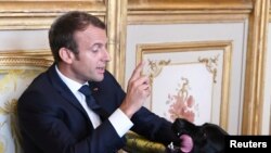 Le président français Emmanuel Macron joue avec son chien au Palais de l’Elysée à Paris, France, 30 août 2017.