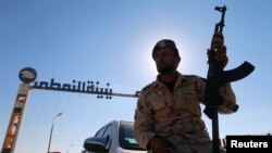 Un membre des forces loyales au maréchal Khalifa Haftar, l'homme fort des autorités de l'est de la Libye, à l’entrée du terminal des installations pétrolières de Zueitina à l’ouest de Benghazi, Libye, 14 septembre 2016.