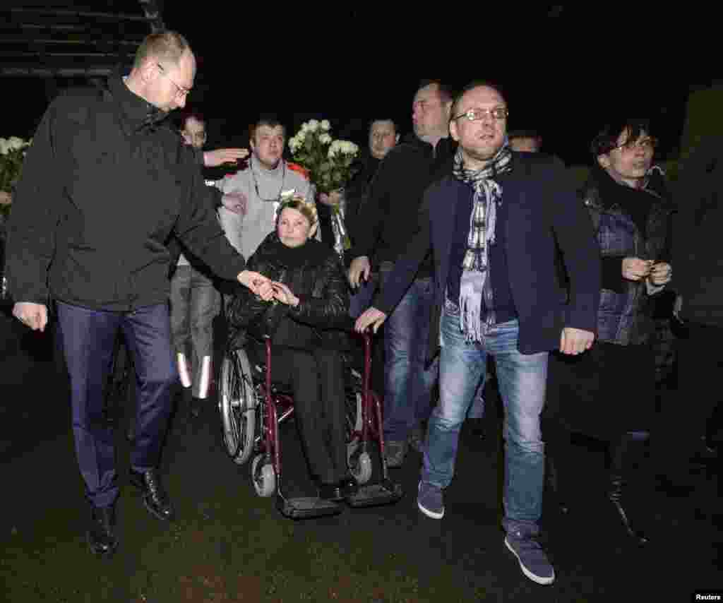 Pemimpin oposisi Ukraina Yulia Tymoshenko (tengah) di atas kursi roda saat tiba di bandar udara Kyiv (22/2), menyusul pembebasannya dari penjara.