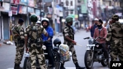 Para petugas keamanan India memeriksa para pengendara motor di jalanan Jammu, 5 Agustus 2019. 