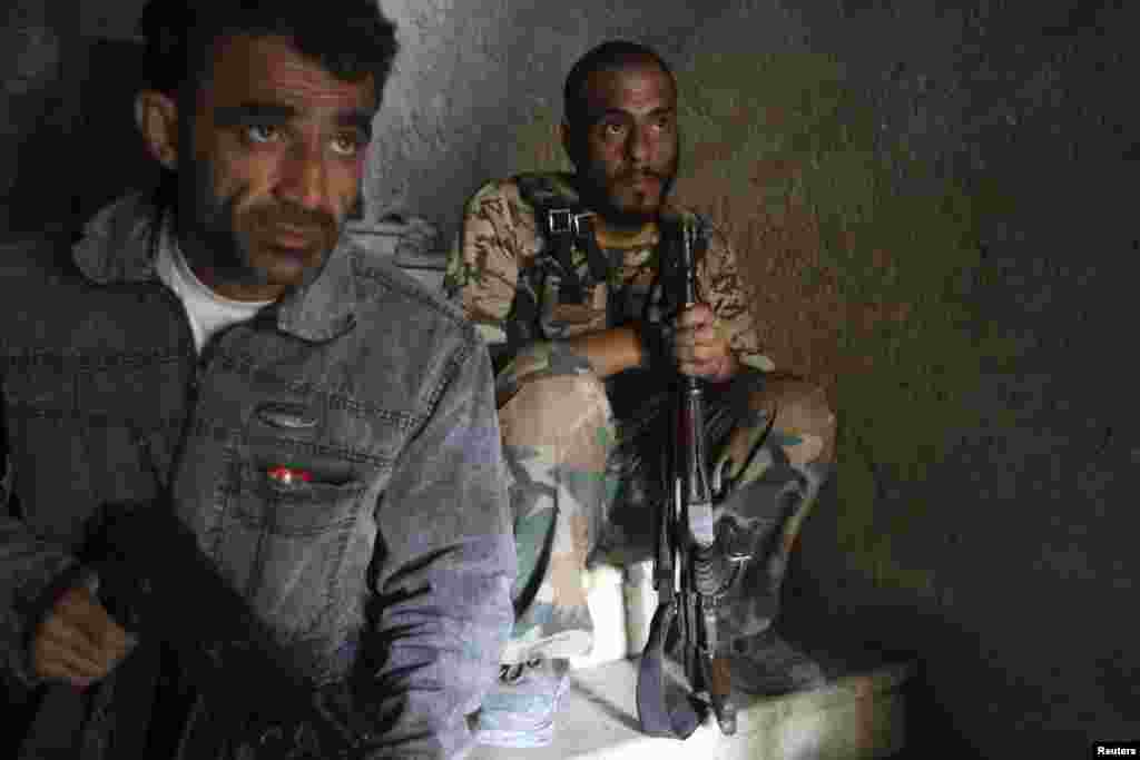 Free Syrian Army fighters take up position on the stairs of a building in Aleppo's Salaheddine neighborhood, July 23, 2013.