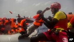 Des agents de l’ONG espagnole Proactiva Open Arms secourent des migrants en plein Méditerranée, à près de 15 miles au nord de Sabratha, Libye, 25 juillet 2017.