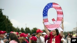 A protesters holds a Q sign waits in line with others to enter a campaign rally with President Donald Trump in Wilkes-Barre, Pa. (AP Photo/Matt Rourke, File)