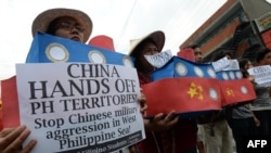Filipino students hold replicas of Chinese maritime surveillance ships during a rally near Malacanang Palace in Manila, March 3, 2016, to denounce reported Chinese vessels dropping anchor near a South China Sea atoll claimed by the Philippines. 