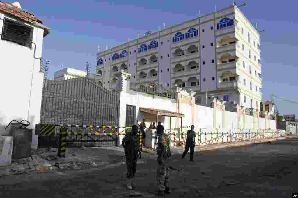 Somali soldiers stand outside the Jazeera Hotel after an attack in Mogadishu, Jan. 2, 2014.