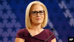 FILE - U.S. Rep. Kyrsten Sinema, D-Ariz., goes over the rules in a television studio prior to a televised debate with U.S. Rep. Martha McSally, R-Ariz., in Phoenix, Oct. 15, 2018.