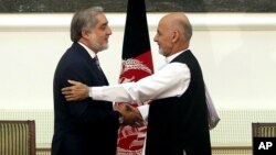 Afghanistan's presidential election candidates Abdullah Abdullah, left, and Ashraf Ghani Ahmadzai shake hands after signing a power-sharing deal at the presidential palace in Kabul, Afghanistan, Sept. 21, 2014