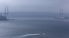 A boat cruises the sea in front of a bridge linking Russian Island (L) to the mainland, in Russia's far Eastern port of Vladivostok, September 5, 2012.