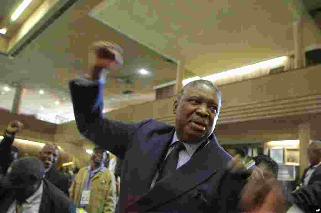 Phelekezela Mphoko scande le slogan de son parti au siège de la Zanu PF à Harare, mercredi 10 décembre 2014.