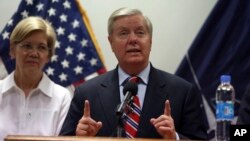FILE - U.S. Senator Lindsey Graham speaks during a press conference at the Resolute Support headquarters in Kabul, Afghanistan, July 4, 2017. Senator Elizabeth Warren, left, also made the trip.
