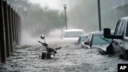 Autos y una moto bajo el agua al paso del huracán Sally por Pensacola, Florida, el 16 de septiembre de 2020.