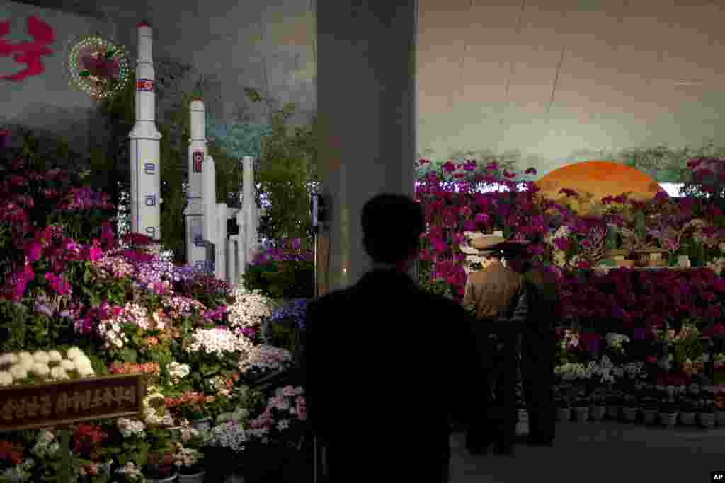 Two military officers admire displays at a flower show featuring thousands of Kimilsungia flowers, named after the late North Korean leader Kim Il Sung, Pyongyang, April 12, 2013.