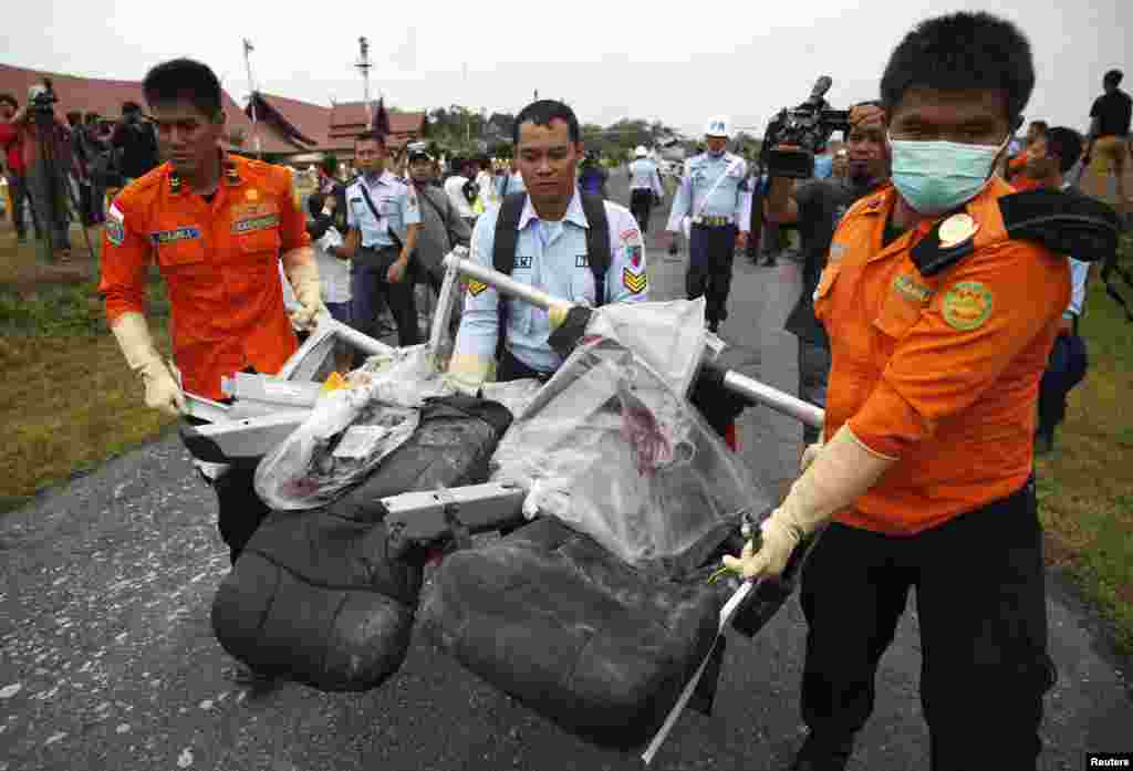 Parts of AirAsia Flight 8501, recovered from the Java Sea, are carried after they were offloaded from a U.S. Navy helicopter at the airport in Pangkalan Bun, Central Kalimantan, Indonesia, Jan. 5, 2015.