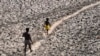 ARCHIVES - Un homme et un garçon traversent le lit asséché de la rivière Yamuna à New Delhi, en Inde, le lundi 2 mai 2022.