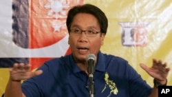 FILE - Mar Roxas gestures as he answers questions from reporters in suburban Quezon City, north of Manila, Philippines.