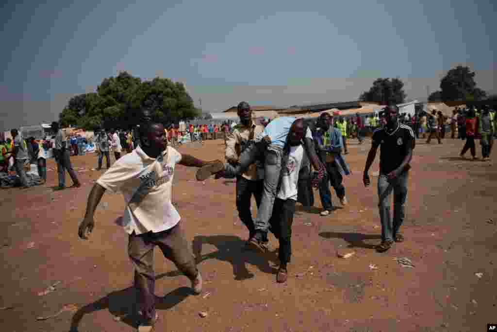 A man is ejected from an aid distribution point after he entered without the ticket that gives access to food and supplies at Mpoko Airport in Bangui, Jan. 7, 2014.