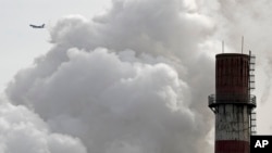ARCHIVO-Un avión comercial de pasajeros vuela cerca de un planta de energía por carbón en Beijing, China. 28-2-17.