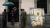 Sudan's President Omar al-Bashir, in doorway, walks past a portrait of late Ethiopian Prime Minister Meles Zenawi, a gift from another delegation, as he arrives to pay his respects to Meles' body lying in state at the national palace in Addis Ababa, Ethio