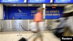 Des passagers passent devant un guichet de la South African Airways (SAA) à l'aéroport international O.R. Tambo de Johannesburg, Afrique du Sud, le 21 janvier 2020. (Photo: REUTERS/Siphiwe Sibeko)