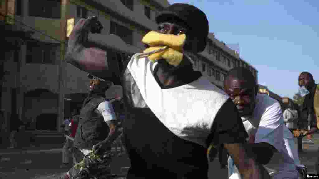 Pemrotes anti-pemerintah melemparkan batu ke arah polisi di&nbsp;Ouagadougou, ibukota Burkina Faso (30/10). 