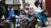 A mother takes time to rest with her children in Harare, Zimbabwe, Nov, 26, 2021. A slew of nations have moved to stop air travel from southern Africa, and stocks have plunged in Asia and Europe in reaction to news of a new, potentially more transmissible COVID-19 variant. 