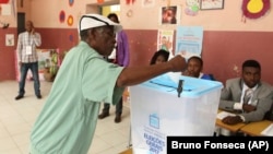 Um eleitor descarrega o voto numa urna, em Luanda. 23 de Agosto, 2017