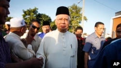 FILE - Malaysian Prime Minister Najib Razak arrives for a Ramadan breakfast at a mosque in Semenyih outside Kuala Lumpur, Malaysia. Malaysia's anti-corruption agency has questioned Najib over deposits of nearly $700 million funds made to his personal bank account.