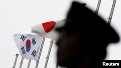 Bendera nasional Jepang dan Korea Selatan berkibar di Kedutaan Korea Selatan di Jepang, tempat mengadakan resepsi untuk memperingati 50 tahun normalisasi hubungan antara Seoul dan Tokyo, di Tokyo, 22 Juni 2015. (Foto: Reuters )
