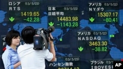 Seorang juru kamera tengah menyoroti indikator elektronik yang terpampang di luar gedung sebuah perusahaan sekuritas di Tokyo (23/5). Indeks Nikkei Jepang turun tajam sebanyak 7,3 persen dan berakhir dengan 1.143 poin lebih rendah dibandingkan saat pembukaan lantai bursa di pagi harinya.