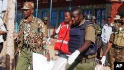 FILE - Kenyan police carry a body of a victim of an al- Shabab attack in Mandera, Kenya, July 7, 2015.