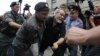 Police detain a supporter of the female punk band 'Pussy Riot' members for violation of law and order outside a court building in Moscow, August 17, 2012. 