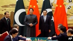 Perdana Menteri China Li Keqiang (kanan) dan Perdana Menteri Pakistan Imran Khan (kiri) menghadiri upacara penandatanganan di Balai Besar Rakyat di Beijing Sabtu, 3 November 2018. (Jason Lee / Pool Photo via AP).