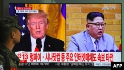 FILE - A South Korean soldier walks past a television screen showing pictures of U.S. President Donald Trump, left, and North Korean leader Kim Jong Un at a railway station in Seoul on March 9, 2018. 