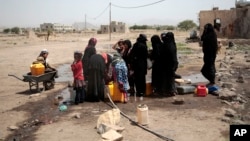 Habitants puisant l'eau d'un puits qui serait contaminée par la bactérie Vibrio cholerae, près de Sanaa, Yemen, 12 juillet 2017.