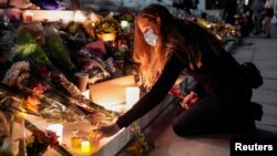 Une femme allumant une bougie sur les marches de la Cour suprême à Washington, en hommage à la juge Ruth Bader Ginsburg, décédée le 18 septembre 2020. (Reiters/Joshua Roberts)