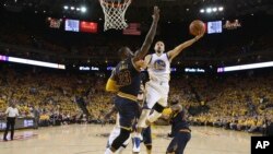 Stephen Curry (30) Golden State Warriors attaque avec le ballon face à LeBron James (23) de Cleveland Cavaliers au cours de la première mi-temps du deuxième match de la finale NBA de basket-ball à Oakland, en Californie., 5 juin 2016. (Ezra Shaw, Getty Images via AP, Pool