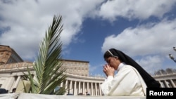 Una monja reza en la misa del Domingo de Ramos en la Plaza de San Pedro del Vaticano, el 24 de marzo de 2024.