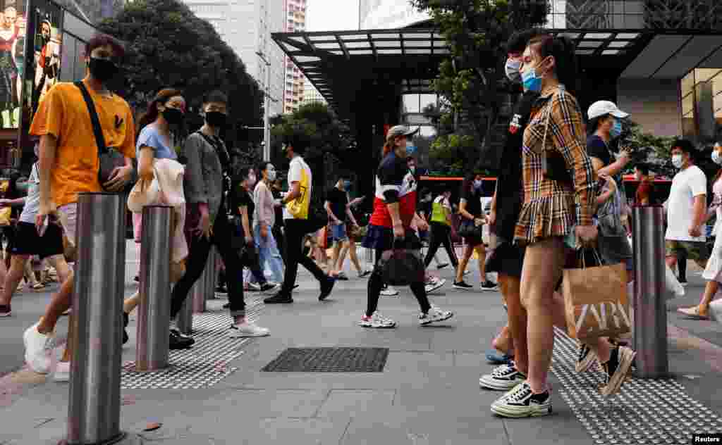 La gente cruza una calle en el distrito comercial de Orchard Road cuando Singapur reabre su economía, en medio del brote de la enfermedad del coronavirus (COVID-19).