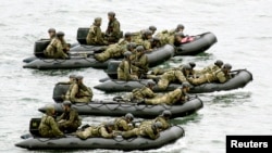 Japan Self-Defense Force (JSDF) soldiers ride rubber boats as they move toward Eniyabanare Island during military exercises, near the town of Setouchi on the southern Japanese island of Amami Oshima, Kagoshima prefecture, May 22, 2014. 
