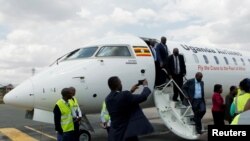 FILE - Passengers disembark from a Uganda Airlines Bombardier CRJ-900 plane during its relaunching flight to Jomo Kenyatta International Airport in Nairobi, Aug. 27, 2019.