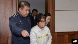 Choi Soon-sil, center, the jailed confidante of disgraced South Korean President Park Geun-hye, appears for the first day of her trial at the Seoul Central District Court in Seoul, South Korea, Dec. 19, 2016.