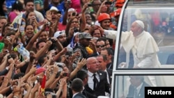 Pope Francis greets the crowd of faithful from his popemobile in downtown Rio de Janeiro, July 22, 2013. 