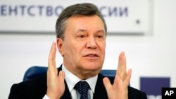 FILE - Former Ukraine President Viktor Yanukovych gestures as he speaks at a news conference in Moscow, Russia, March 2, 2018.