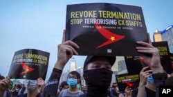 Demonstrators hold signs opposing the recent firings of Cathay Pacific employees during a demonstration at the Edinburgh Square in Hong Kong, Aug. 28, 2019. 