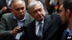 Mexico's President Andres Manuel Lopez Obrador waves as he arrives for the swearing-in ceremony for Mayor-elect Claudia Sheinbaum, in Mexico City, Dec. 5, 2018.