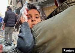 Palestinac nosi ranjeno dijete, 20. decembar 2024. (Foto: REUTERS/Khamis Said)